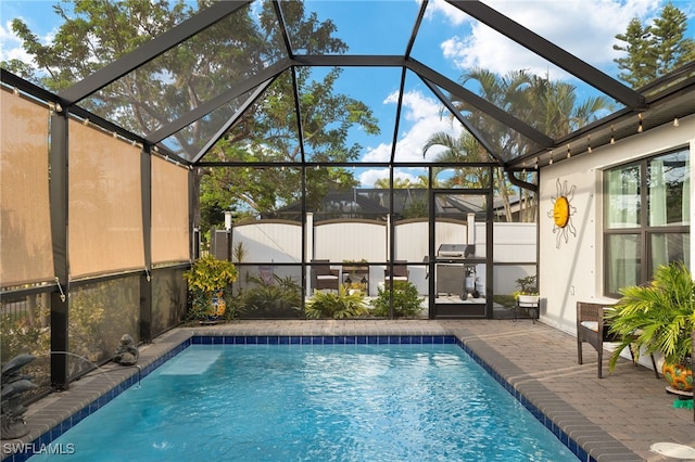 view of swimming pool featuring a patio and glass enclosure