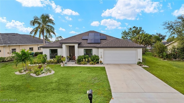 view of front of property with a garage, solar panels, and a front lawn