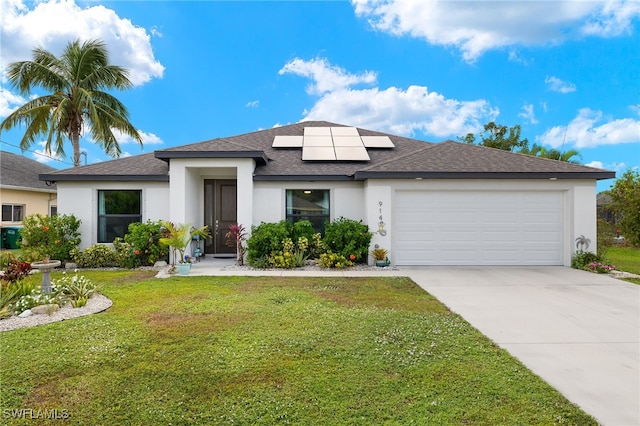 view of front of home with a garage, a front lawn, and solar panels