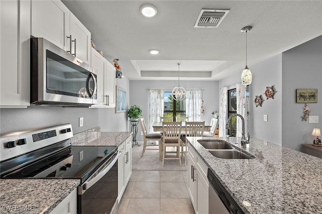 kitchen featuring white cabinetry, appliances with stainless steel finishes, sink, and light stone countertops