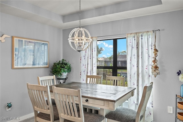 dining room with a raised ceiling and an inviting chandelier