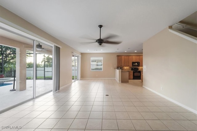 unfurnished living room featuring a wealth of natural light, light tile patterned floors, and ceiling fan