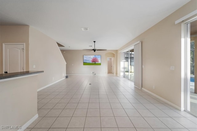 unfurnished living room featuring ceiling fan and light tile patterned floors