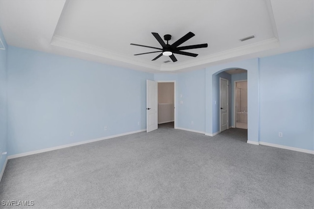 carpeted spare room featuring ceiling fan, crown molding, and a tray ceiling