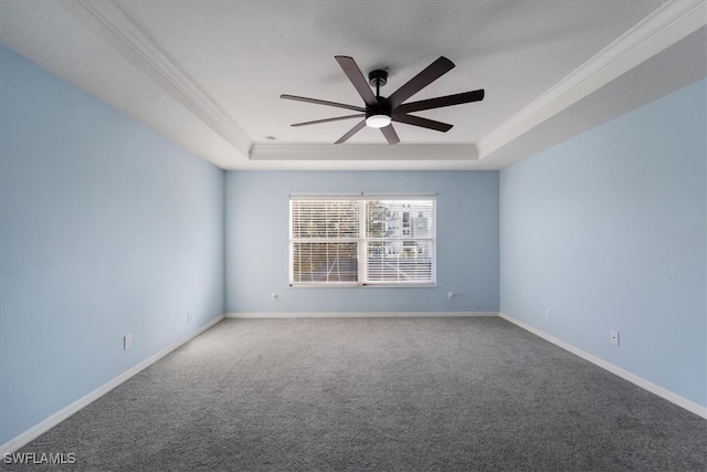 carpeted spare room with a tray ceiling, ceiling fan, and crown molding