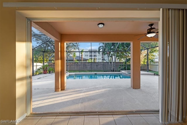 view of pool with glass enclosure, a patio area, and ceiling fan