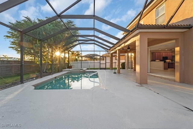 view of pool featuring glass enclosure, a patio, ceiling fan, and an in ground hot tub