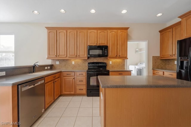 kitchen featuring separate washer and dryer, sink, black appliances, tasteful backsplash, and light tile patterned floors