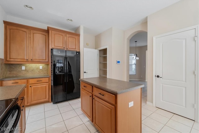 kitchen featuring black appliances, a kitchen island, tasteful backsplash, and light tile patterned floors