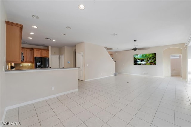 unfurnished living room featuring ceiling fan and light tile patterned floors