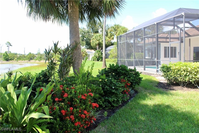 view of yard with glass enclosure and a water view