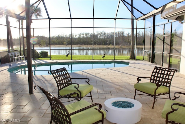 view of swimming pool featuring a water view, glass enclosure, an outdoor fire pit, and a patio area