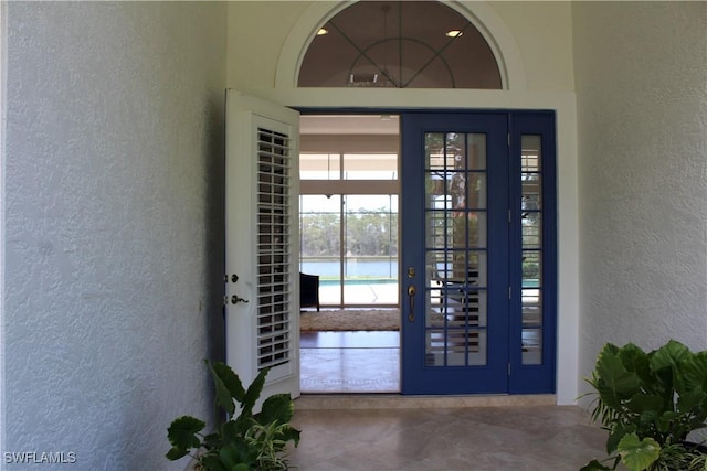 property entrance featuring a water view and stucco siding