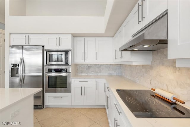 kitchen featuring under cabinet range hood, white cabinetry, light countertops, appliances with stainless steel finishes, and backsplash