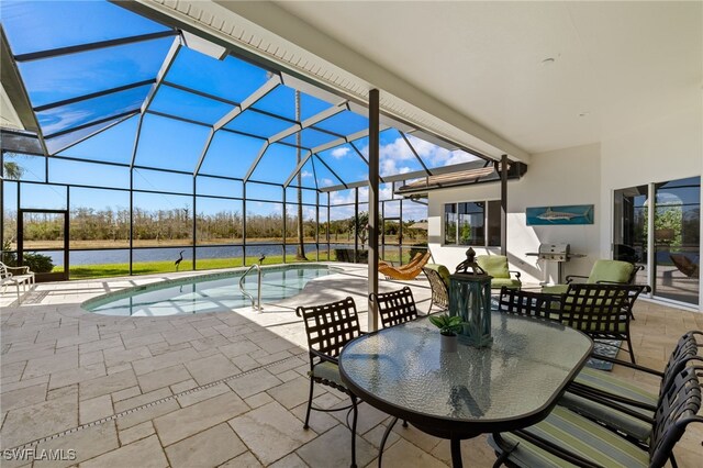 view of patio / terrace with outdoor dining area, a water view, a lanai, and an outdoor pool