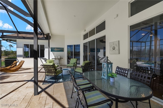 view of patio with glass enclosure and outdoor dining area