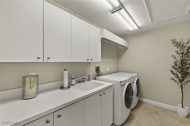 clothes washing area featuring cabinet space, light tile patterned floors, baseboards, separate washer and dryer, and a sink