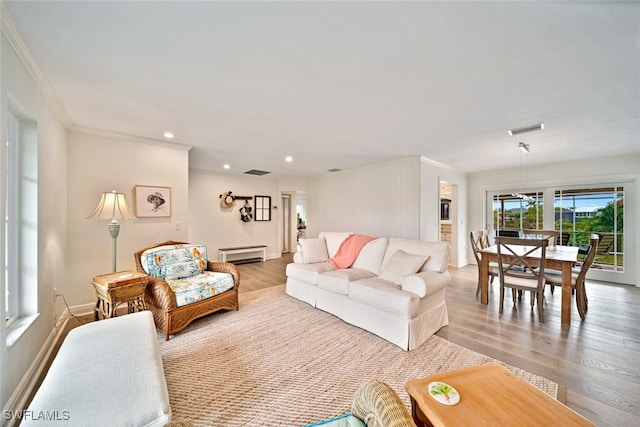 living room with ornamental molding, light wood-type flooring, and a baseboard heating unit