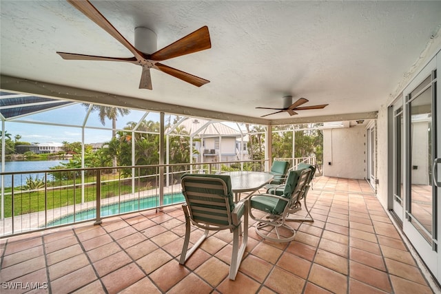 unfurnished sunroom featuring a swimming pool, ceiling fan, and a water view