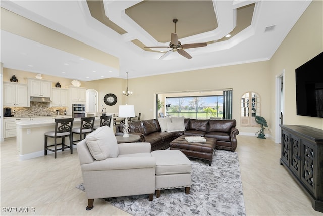 living room with ceiling fan with notable chandelier, a raised ceiling, and ornamental molding