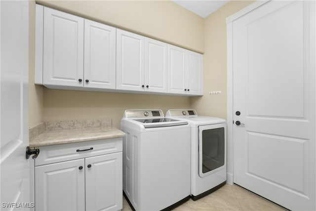 washroom with cabinets, light tile patterned floors, and separate washer and dryer