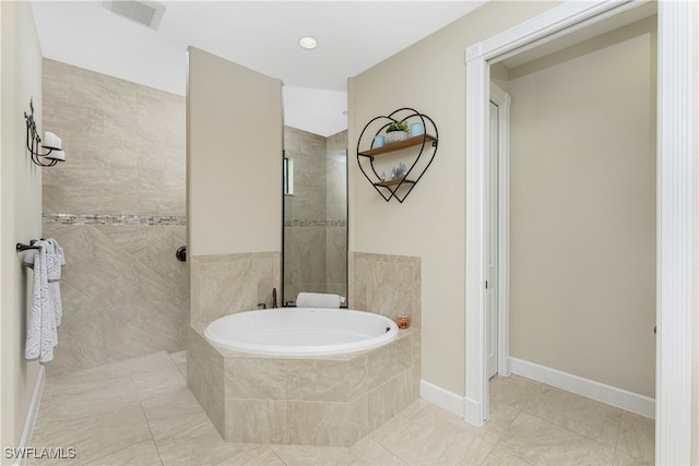 bathroom featuring tile patterned floors and tiled tub