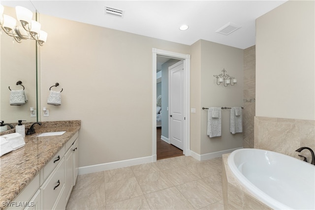 bathroom featuring vanity and tiled tub