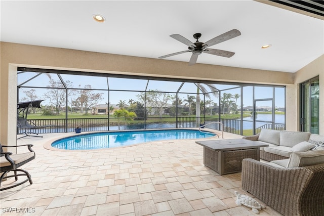 view of pool with glass enclosure, a patio, and an outdoor living space