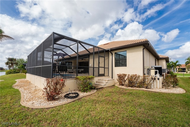 rear view of property with a lawn, a lanai, and a swimming pool