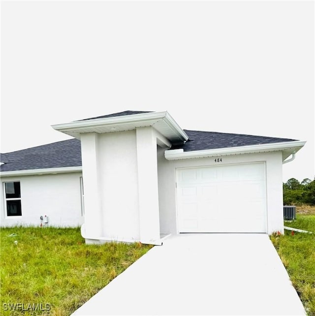 view of home's exterior with central AC, a garage, and a lawn