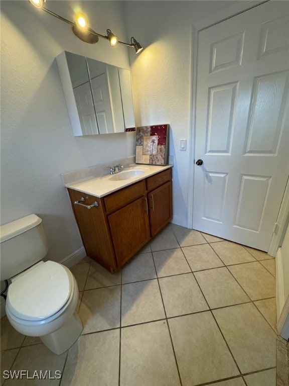 bathroom featuring toilet, vanity, and tile patterned floors