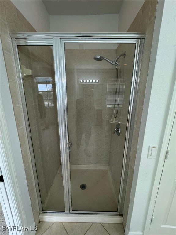 bathroom featuring tile patterned floors and a shower with shower door