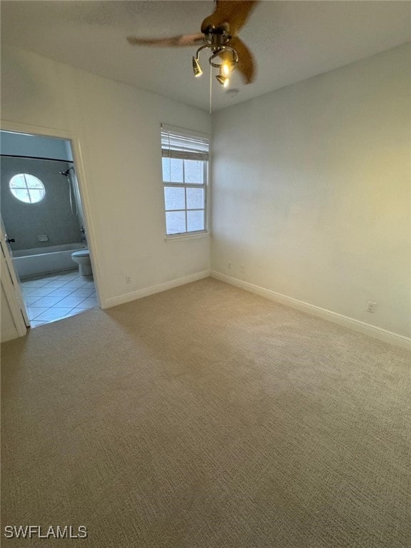 carpeted spare room with ceiling fan