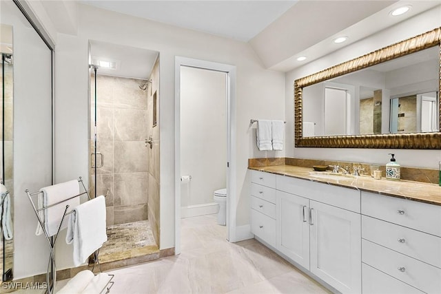 bathroom featuring vanity, toilet, and a shower with door