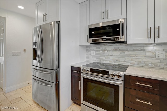 kitchen featuring decorative backsplash, dark brown cabinetry, white cabinetry, and stainless steel appliances