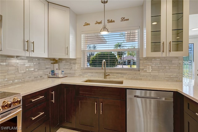 kitchen with white cabinets, hanging light fixtures, sink, decorative backsplash, and appliances with stainless steel finishes