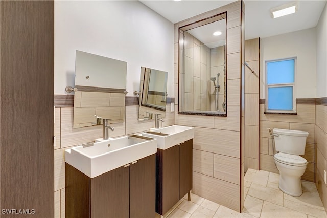 bathroom with vanity, toilet, and tile walls