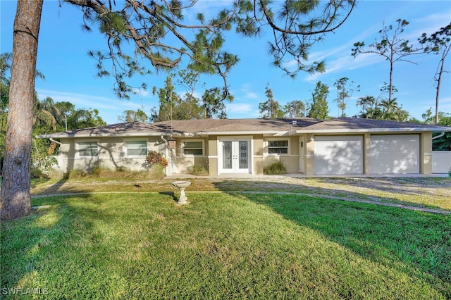 ranch-style home featuring french doors, a front yard, and a garage