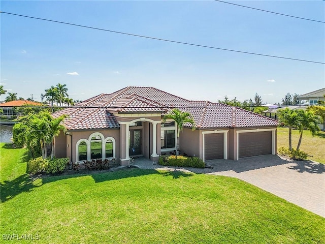 mediterranean / spanish-style home featuring a front yard and a garage