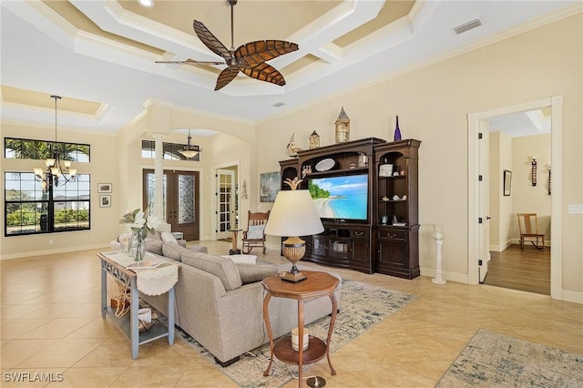 living room with french doors, a high ceiling, a raised ceiling, ceiling fan with notable chandelier, and ornamental molding