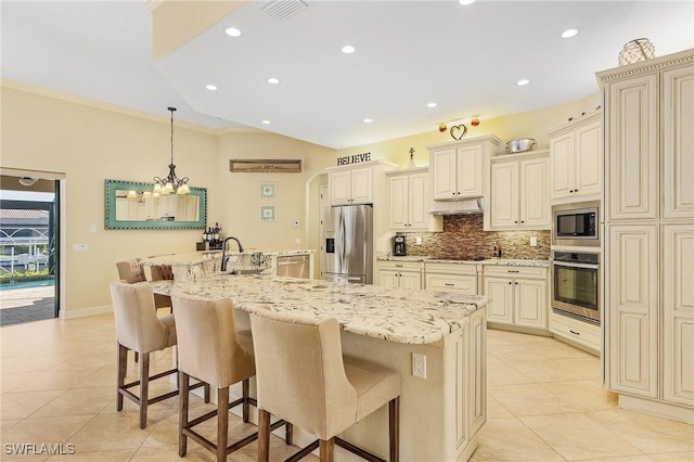 kitchen featuring a large island, stainless steel appliances, backsplash, cream cabinets, and pendant lighting