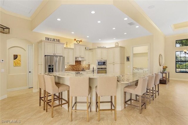 kitchen with a kitchen breakfast bar, light stone countertops, and stainless steel appliances