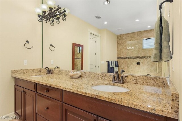 bathroom featuring a tile shower and vanity