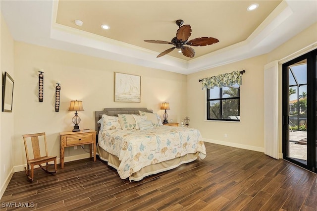 bedroom featuring ceiling fan, access to exterior, ornamental molding, and a tray ceiling