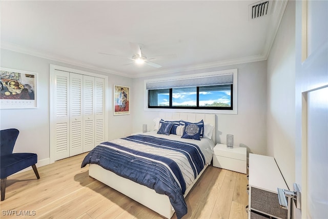 bedroom featuring ornamental molding, a closet, light hardwood / wood-style floors, and ceiling fan