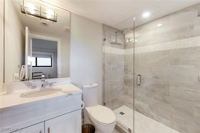 bathroom with a shower with door, vanity, and toilet