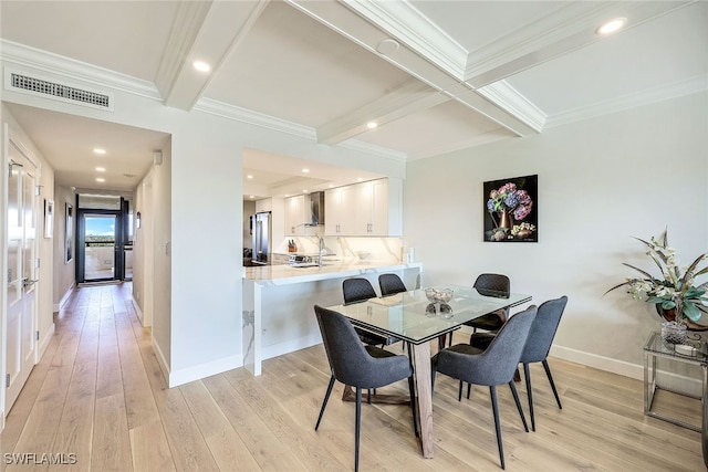 dining space with beam ceiling, light hardwood / wood-style flooring, and ornamental molding