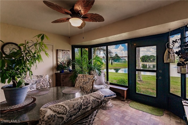 sunroom with a water view, a healthy amount of sunlight, and ceiling fan