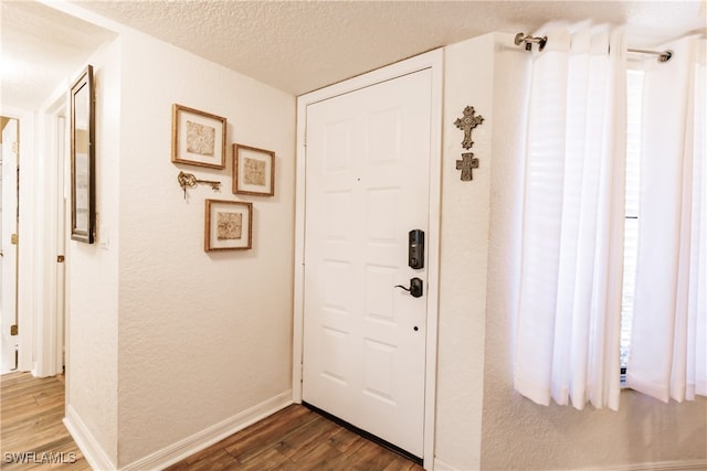 doorway featuring a textured ceiling and dark hardwood / wood-style floors