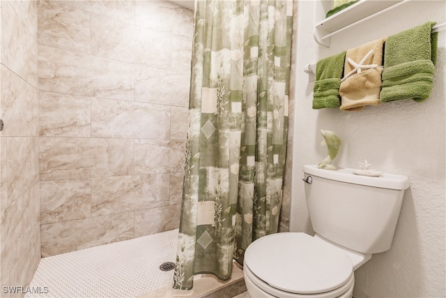 bathroom with curtained shower and toilet